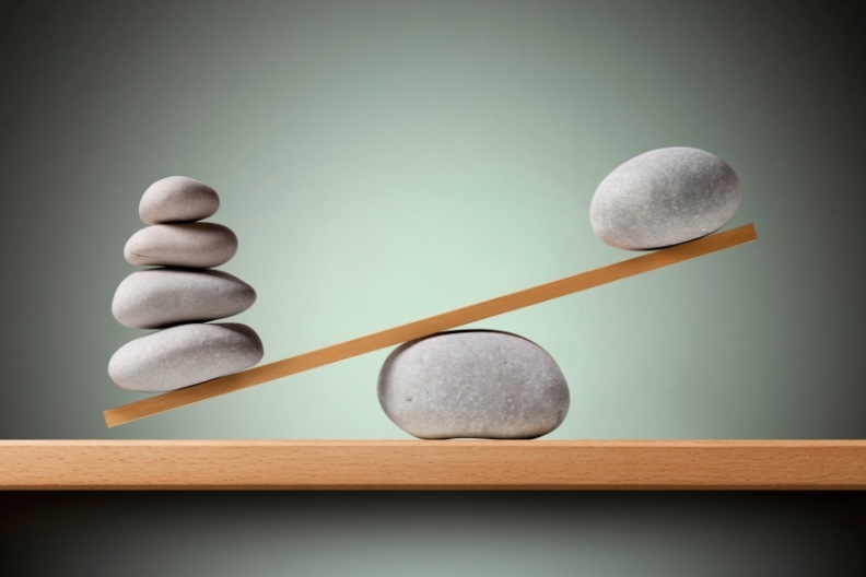Balanced stones on a seesaw illustrating investment diversification strategies at Financial Consulate.
