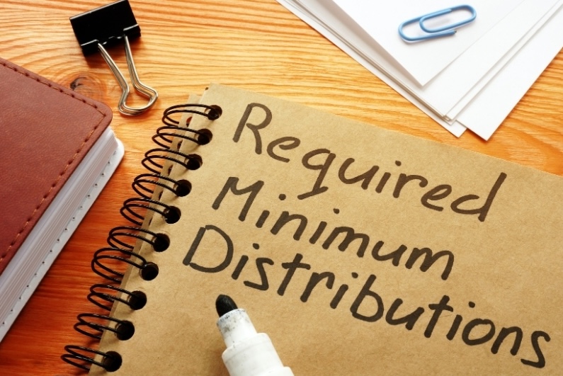 Required Minimum Distributions handwritten on a notebook for retirement RMD timing planning.